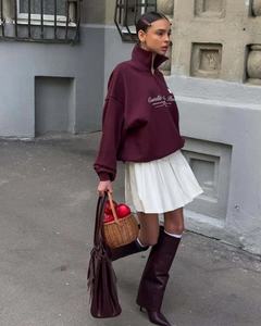 Street style view of deep burgundy half-zip sweatshirt with white script logo print