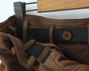 Détail de la taille élastique réglable avec boutons sur la jupe en laine marron