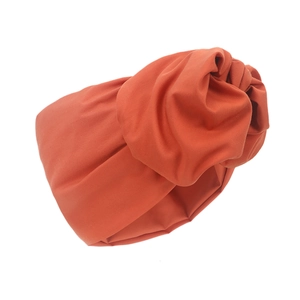 Detailansicht des orangefarbenen Turban-Huts mit stilvollem Criss-Cross-Knotendesign