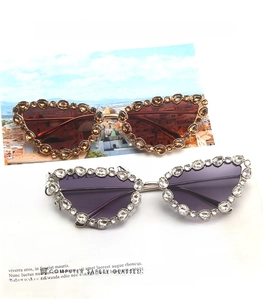 Detail of luxury cat-eye sunglasses with rhinestone metal frames in gold and silver colors