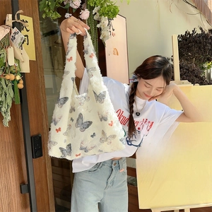 Close-up of white plush tote bag featuring elegant butterfly patterns and soft texture