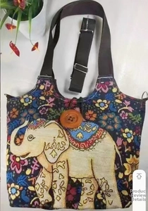 Detail der Ethno-Canvas-Tasche mit bunter Elefantenstickerei und großem Holzknopf
