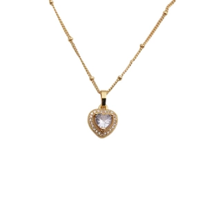 Collier avec pendentif cœur en cuivre doré et pierres de zircon sur fond blanc