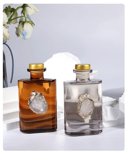 Detail of amber and gray glass aroma diffusers with decorative gold-edged agate stones