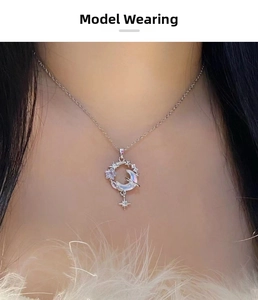 Detailed view of moonstone star and moon pendant necklace worn on a model's neck