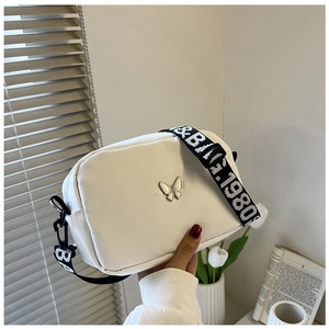 Detailed shot of white nylon square bag with silver butterfly and 1980s B&B strap
