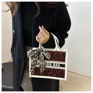 Detail of leopard print tote bag with white trim, silk scarf, and 'FAHION BAG' text