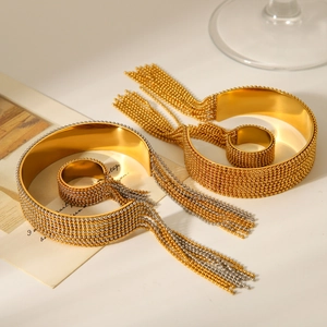 Detail of mixed-tone gold and silver tassel bracelet set with metal bead texture