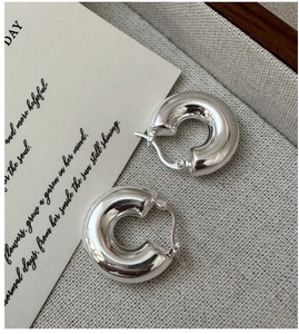 Boucles d'oreilles créoles minimalistes en argent S925 poli sur tissu gris chiné