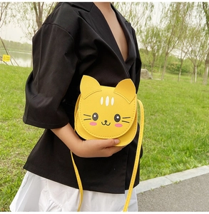 Child wearing a cute yellow cat-shaped mini crossbody bag with a PU leather strap outdoors