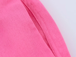 Détail de la texture du tissu en lin rose et des coutures de qualité supérieure sur la poche