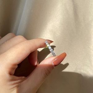 Detail shot of a silver eternity ring with sparkling round stones held by hand