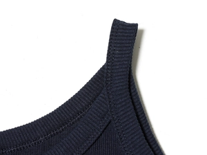 Detailed close-up of dark blue ribbed fabric and stitching on a casual knitted vest