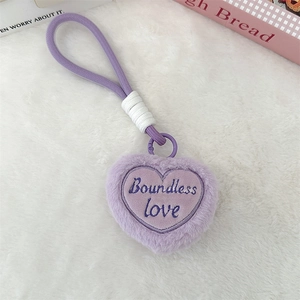 Macro shot of purple plush heart keychain with Boundless Love embroidery and woven strap