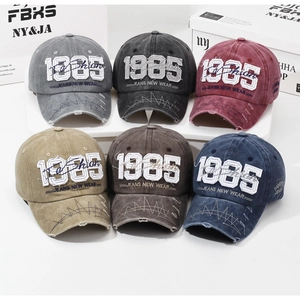 Detailed macro of vintage washed baseball caps with 1985 embroidery and distressed brims