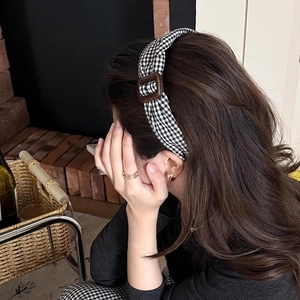 Serre-tête rétro à carreaux noir et blanc avec boucle marron porté par un mannequin