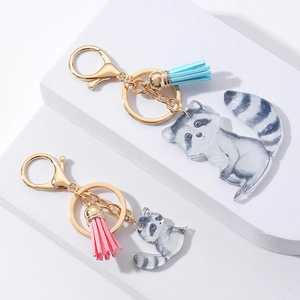 Detail of couple otter acrylic keychains with colorful tassels and golden clasps