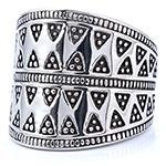 Detailed macro shot of vintage punk wide band ring with triangular geometric relief pattern