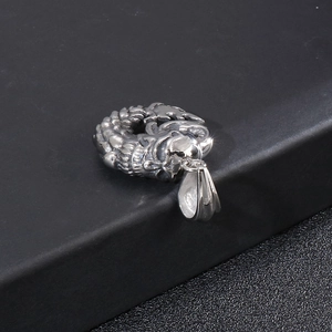 Detailed close-up of a silver stainless steel dragon pendant with intricate carving details