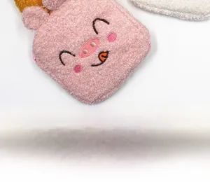 Detailed close-up of a pink sherpa fleece storage pouch with embroidered pig face