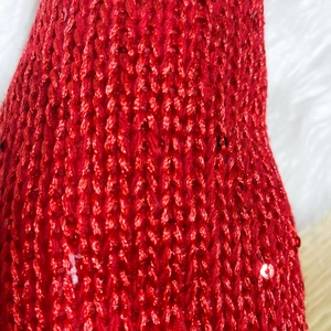 Close-up of red sequined knit fabric for Christmas Rudolph elk holiday decorations
