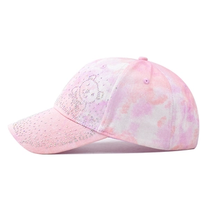 Pink tie-dye baseball cap with sparkling rhinestone bear design on a white background
