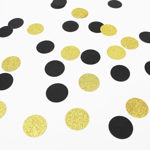 Close-up of sparkling gold glitter and solid black round sequins for party table decor