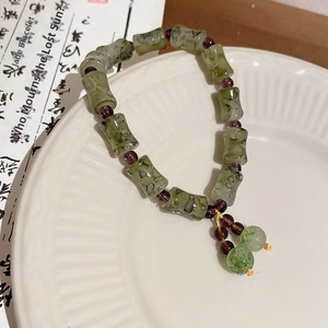 Gros plan de perles en jade vert style bambou avec touches de verre violettes