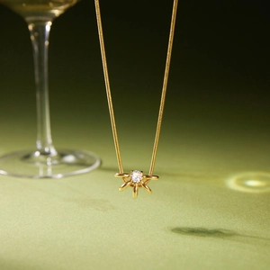 Détail du collier chaîne serpent 18K avec pendentif soleil et zircon cubique brillant