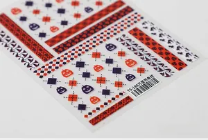 Close-up of 5D Halloween nail art stickers with orange stripes and pumpkin patterns