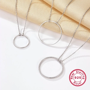 Vue détaillée de pendentifs anneaux en argent 925 avec des pierres de zircone blanches