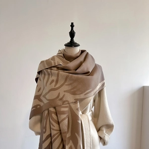 Elegant camel cashmere blend scarf with abstract patterns shown on a female mannequin