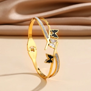 Detail of gold-plated stainless steel cuff with butterfly inlays and pavé crystals