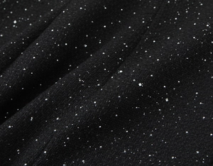 Macro detail of black tweed fabric with woven silver sequins for luxury womens jacket