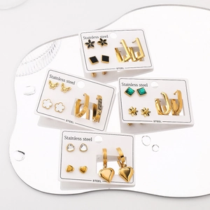 Sets de boucles d'oreilles en acier doré avec motifs cœur et trèfle sur miroir