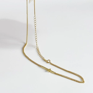 Minimalist gold sideways cross choker necklace with adjustable chain on white background