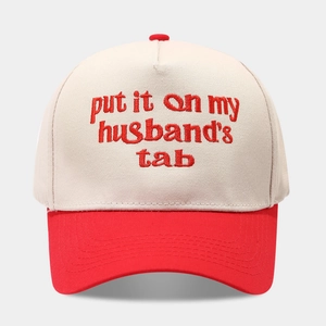 Detail der roten Stickerei 'put it on my husband's tab' auf beiger Trucker Cap