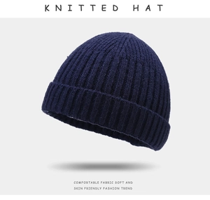 Detail of navy blue knitted beanie hat showing premium ribbed texture and soft fabric