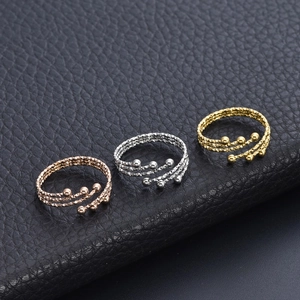 Macro detail of three-tone stainless steel coiled rings with small bead accents