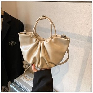 Detail of cream pleated cloud bag with soft leather texture and stylish top handle