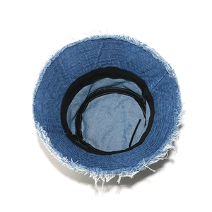 Detail view of denim bucket hat showing frayed edges and adjustable inner drawstring