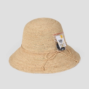 Detailed macro view of woven raffia sun hat texture with UV care tag and tie bow