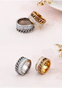 Macro shot of gold and silver spinning chain rings featuring rectangular zircon inlays