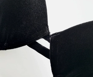 Detailed macro view showing the soft black velvet texture and stitching of the bra strap
