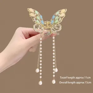 Detail of golden butterfly hair claw with 11cm pearl tassels and colorful gems