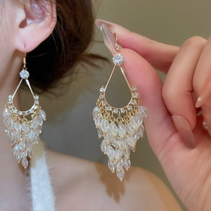 Detail of elegant gold drop fringe earrings with clear crystals and sparkling tassels