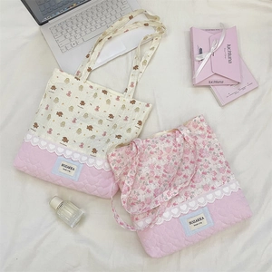 Close-up of quilted tote bag featuring animal prints, lace trim, and heart patterns