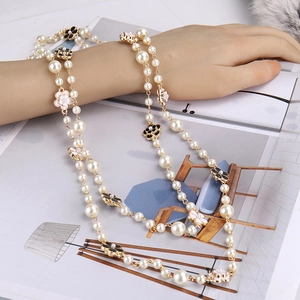 Elegant multi-layer long pearl necklace with black and white camellia flower charms