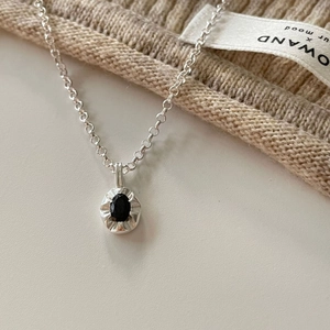 Detailed close-up of a 925 silver necklace featuring a black oval gemstone pendant