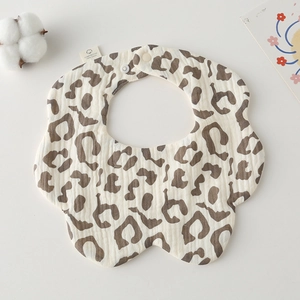 Detail of soft cotton gauze baby bib with leopard print pattern and snap button closure